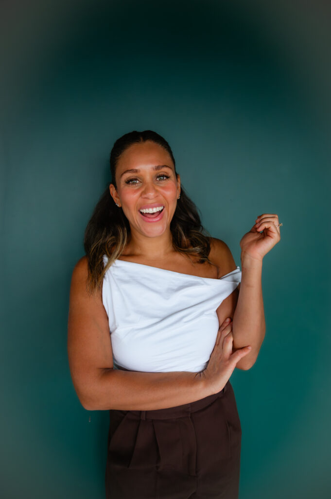 woman laughing in front of a teal backdrop during nebrand photos