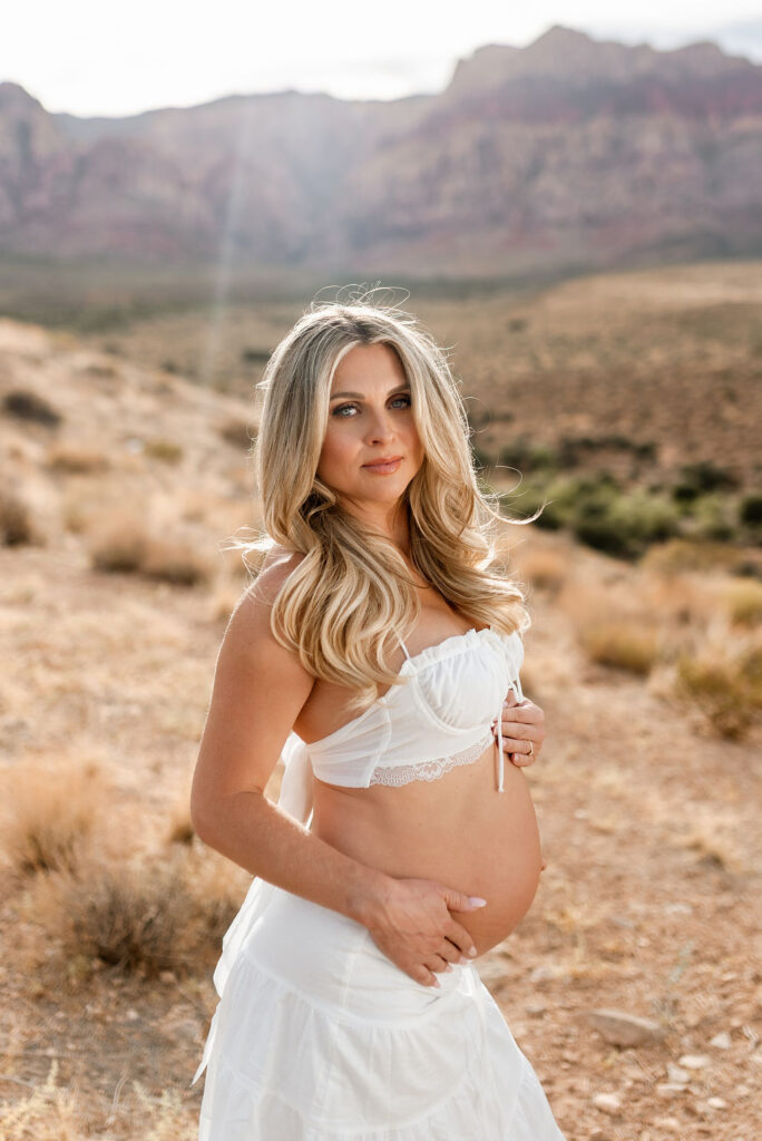 Maternity portrait in white top with mountains in background at Red Rock Canyon