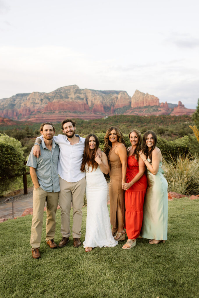 Wedding group portrait with bride and groom in front of Sedona red rocks