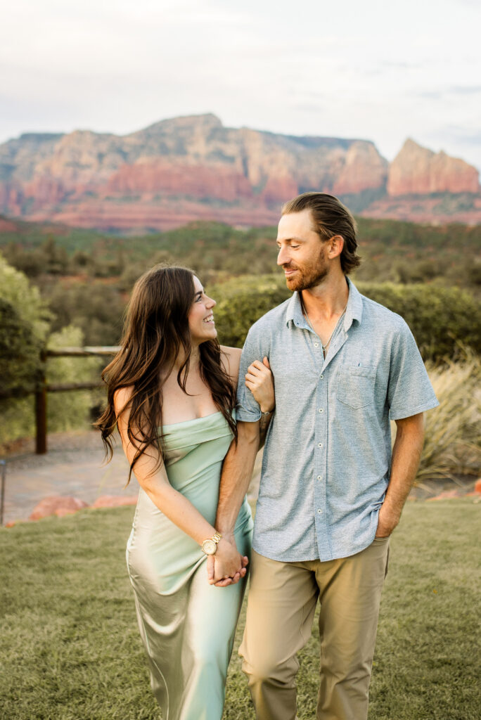 Couple holding hands with Sedona red rock mountains in the background

