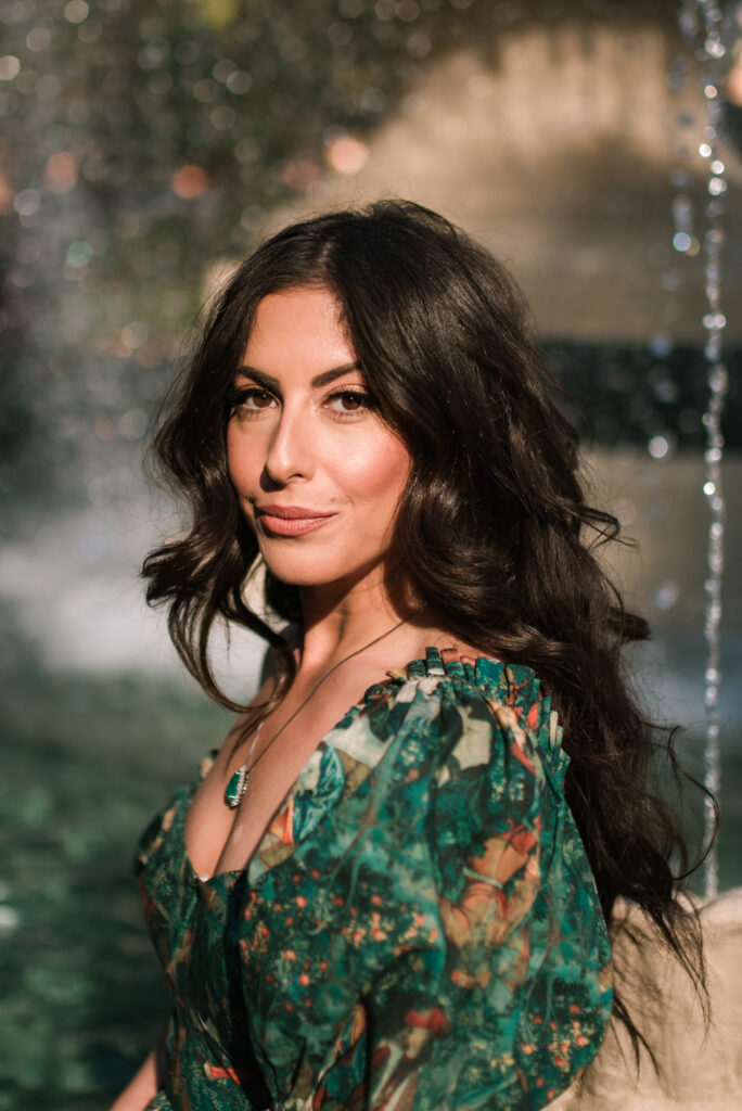 Close up portrait of woman in a green dress near a fountain at the Bellagio in Las Vegas.