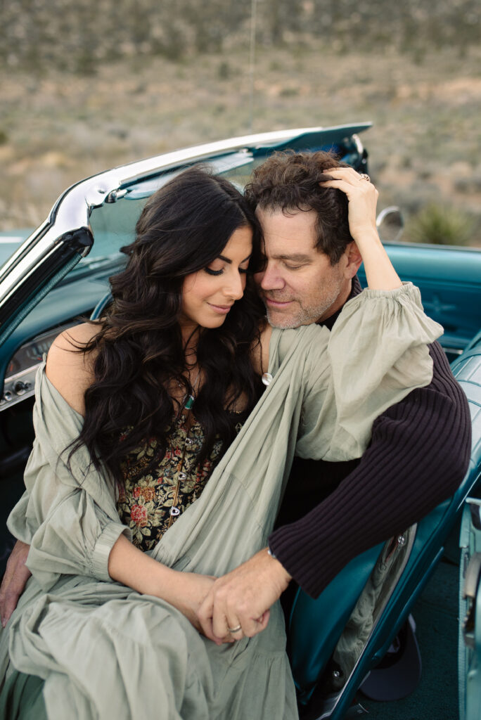 Couple cuddling in a vintage blue convertible at Red Rock Canyon near Las Vegas.